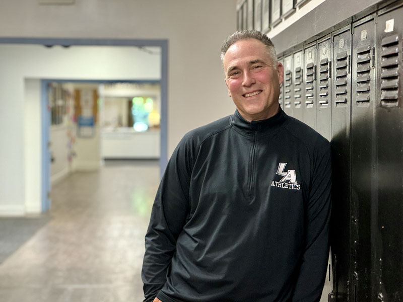 Lincoln Academy Headmaster Jeff Burroughs leans against lockers at the school in Newcastle on Thursday, Aug. 22. In addition to being the schools headmaster, Burroughs is the boys varsity soccer coach and an avid fly fisherman. (Johnathan Riley photo)