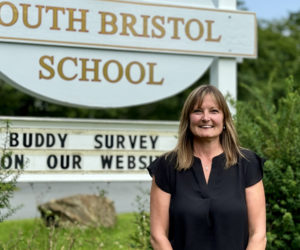 South Bristol Schools new principal, Laurie Stiles, stands in front of the schools sign on Friday, Aug. 16. Stiles said she looks forward to helping SBS continue forward in a good direction while developing and deepening the communitys connection with the school. (Johnathan Riley photo)