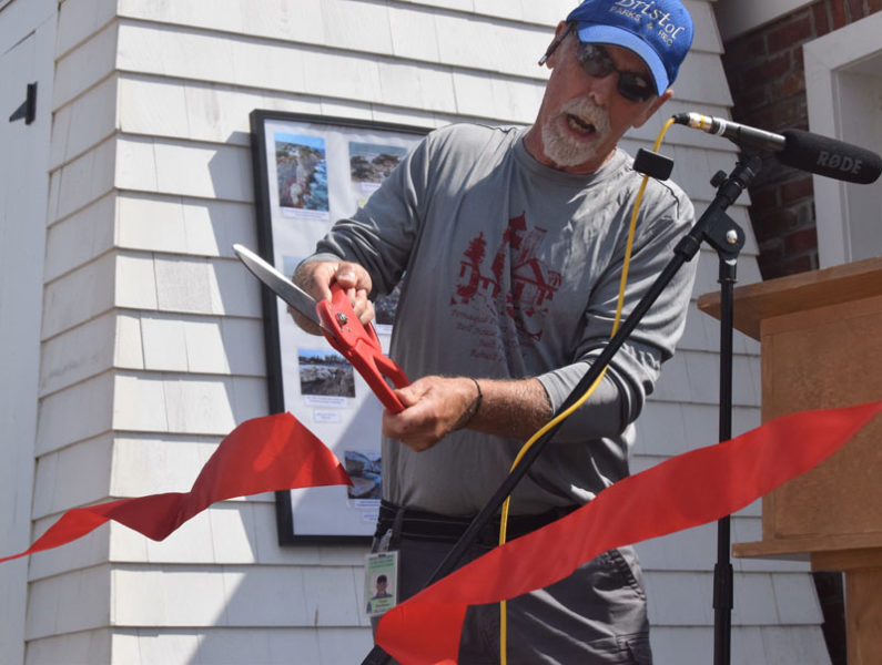 Bristol Parks and Recreation Commission Chair Clyde Pendleton cuts a ribbon to signify the completion of work to restore and fortify the bell house at Pemaquid Point Lighthouse Park in Bristol on  Saturday, Sept. 14. The building was partially destroyed by back-to-back storms in January. (Nolan Wilkinson photo)