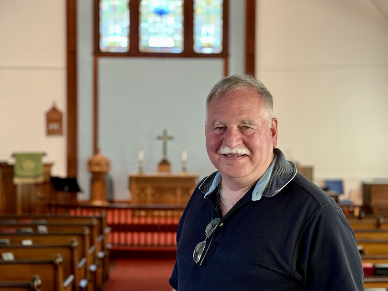 Pastor Ernie Farrar stands in the aisle between the pews of the New Harbor United Methodist Church on Thursday, Sept. 5. Farrar has returned to the congregation after 17 years of serving in other churches and communities in New England. (Johnathan Riley photo)