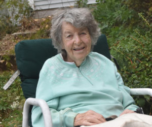 Elaine Robbins sits in front of her home in Waldoboro. Robbins, a longtime educator who taught students ranging in age from kindergarten to adults throughout her career, is an avid knitter who sells about 100 pairs of mittens yearly from her front porch. (Molly Rains photo)