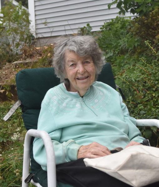 Elaine Robbins sits in front of her home in Waldoboro. Robbins, a longtime educator who taught students ranging in age from kindergarten to adults throughout her career, is an avid knitter who sells about 100 pairs of mittens yearly from her front porch. (Molly Rains photo)