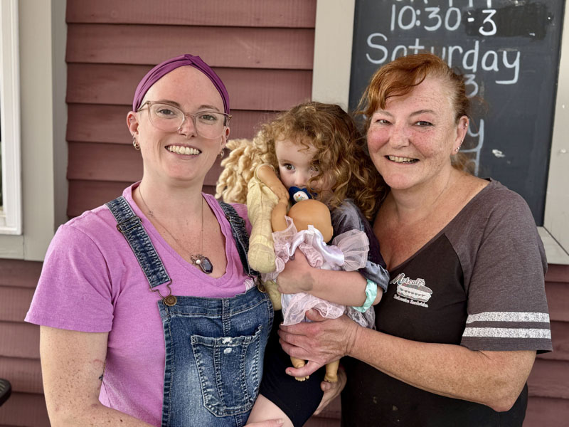 Julie Kaplinger (right) and her daughter, Kaydie Russell, both hold Russells daughter, Annaka, outside of Metcalfs Submarine Sandwiches in Damariscotta on Wednesday, Sept. 18. Kaplinger, who owns the sandwich shop, is also a music lover and antique car enthusiast. (Johnathan Riley photo)