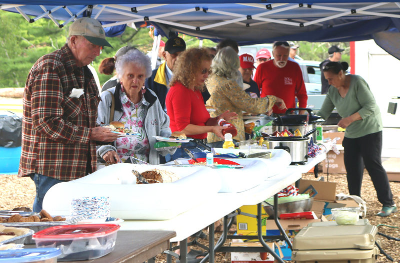 Attendees of the Waldoboro Republican Town Committee's third annual Great American Family Picnic serve themselves lunch the afternoon of Saturday, Sept. 7. On the menu for the event's meal were hamburgers, hot dogs, chips, and other sides, drinks, and desserts. (Piper Pavelich photo)