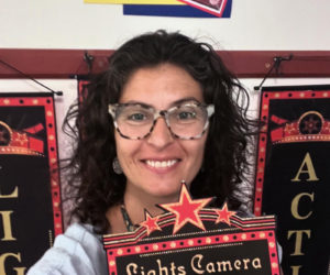 Suzanne Balbo, director of the Whitefield Library, holds up a sign for "Lights! Camera! Action!" (Photo courtesy Whitefield Library)