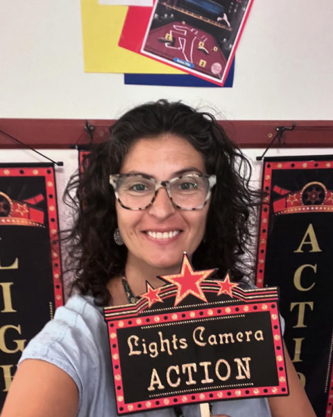 Suzanne Balbo, director of the Whitefield Library, holds up a sign for "Lights! Camera! Action!" (Photo courtesy Whitefield Library)