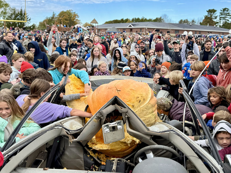 A crowd swarms around a car destroyed by a 1,000-pound pumpkin at Great Salt Bay Community School in Damariscotta on Sunday, Oct. 13. This year marked the pumpkin drops return to the Damariscotta Pumpkinfest and Regatta schedule for the first time since 2019. (Johnathan Riley photo)