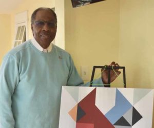 Edgecomb artist Leeroy Gandy stands with a barn quilt he painted, featuring a cardinal and blue jay. Gandy, a lifelong artist and mathematician, said he takes inspiration from birds and the natural beauty of the Midcoast for his barn quilts and other artistic pursuits. (Molly Rains photo)