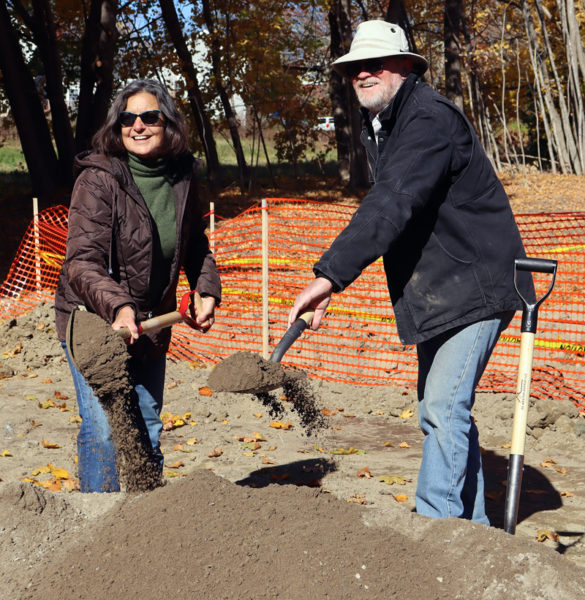 Developer Rob Nelson (right) and his wife, Stephanie Nelson, symbolically break ground on an affordable housing development at 16 Mills Road in Newcastle on Monday, Oct. 28. The couple and roughly 45 others gathered at the property to celebrate the start of work on the development. (Piper Pavelich photo)