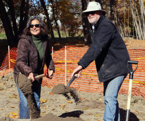 Developer Rob Nelson (right) and his wife, Stephanie Nelson, symbolically break ground on an affordable housing development at 16 Mills Road in Newcastle on Monday, Oct. 28. The couple and roughly 45 others gathered at the property to celebrate the start of work on the development. (Piper Pavelich photo)