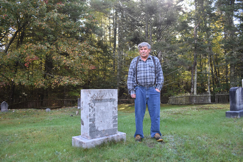 Neal Shuman, of Waldoboro, stands with the gravestone of his relatives, including his great-uncle Harold R. Shuman, in the Oliver and Bernheimer Cemetery in North Waldoboro. Shuman said his father told him about the family members buried there when he was young. Now, Shuman helps maintain the cemetery and, with his children, has restored the site over the course of about a decade. (Molly Rains photo)