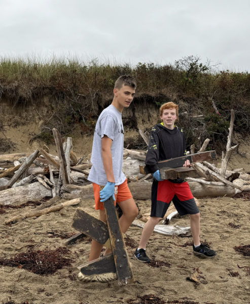 Lincoln Academy ninth graders Calvin Wicks and Tryston Lambert move washed up lumber off the beach at Reid State Park as part of Lincoln Academys beach cleanup field trip. (Photo courtesy Lincoln Academy)