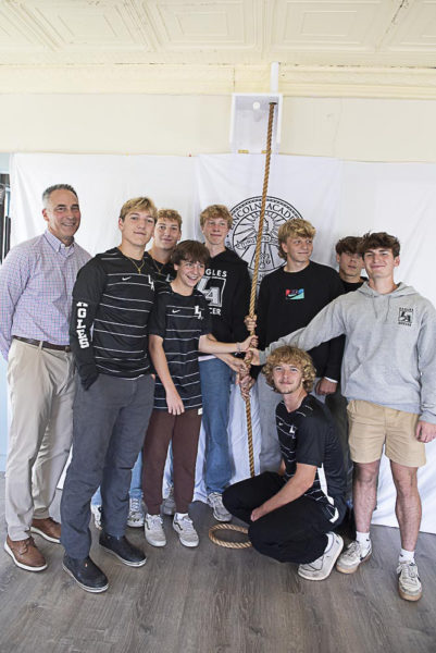 The Lincoln Academy boys soccer team, coached by Head of School Jeff Burroughs, celebrate its second consecutive KVAC championship in 2023 during a bell-ringing ceremony Saturday, Sept. 28. From left: Jeff Burroughs, Drew Hunt, E.J. Hunt, George Seigel, Nestor Powers, Adam St. Cyr, Will Bradley, Cole Workman, and Peter Thelander. (Photo courtesy Lincoln Academy)