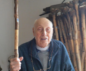 Errol T. Clark with a bucket full of gray birch walking sticks he made. (Paula Roberts photo)