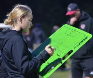 Lincoln Academy graduate Tatum Hancock writes down the lineup for her Hall-Dale girls soccer team during a 2-0 playoff win over Winthrop on Tuesday, Oct. 29 in Hallowell. (Paula Roberts photo)