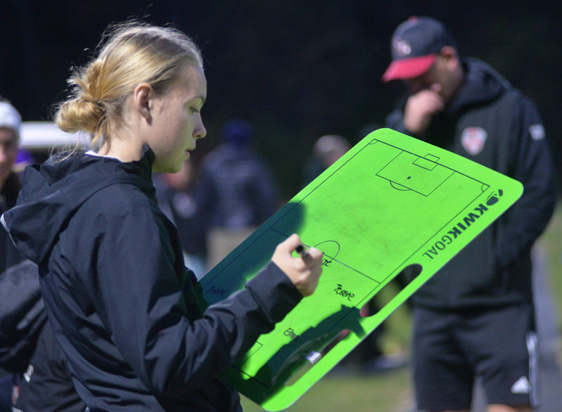 Lincoln Academy graduate Tatum Hancock writes down the lineup for her Hall-Dale girls soccer team during a 2-0 playoff win over Winthrop on Tuesday, Oct. 29 in Hallowell. (Paula Roberts photo)