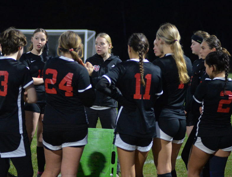 Head coach Tatum Hancock (center) gives a pre-game talk to the undefeated Hall-Dale girls soccer team before a 2-0 playoff win against Winthrop on Tuesday, Oct. 29 in Hallowell. Hancock is a 2020 graduate of Lincoln Academy. (Paula Roberts photo)