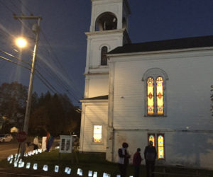 Attendees light luminaires at the Broad Bay Congregational Church in Waldoboro. (Courtesy photo)