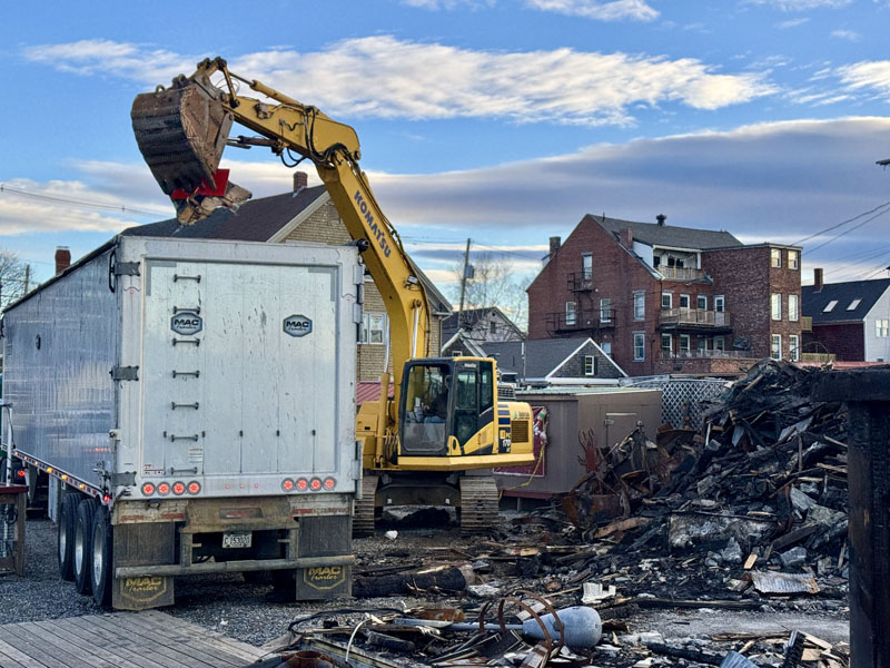 An excavator from Hanley Construction, of Bristol, begins removing debris on Monday, Nov. 25 from where Schooner Landing Restaurant and Marina burned down in September. According to Hanley Construction co-owner Stewart Hanley, the estimate for the debris removal is for 205 tons, or 410,000 pounds. (Johnathan Riley photo)