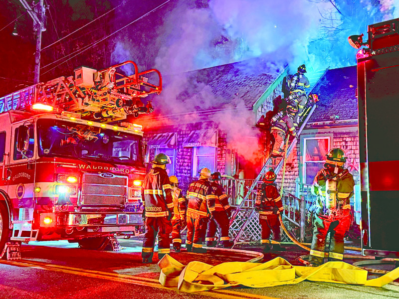 Firefighters climb onto the roof of the building at 258 Jefferson St. in Waldoboro on Sunday, Nov. 17 to extinguish a structure fire. Waldoboro Fire Chief Paul Smeltzer said the cause of the fire is unknown, but is being investigated by the Office of Maine State Fire Marshal. (Johnathan Riley photo)