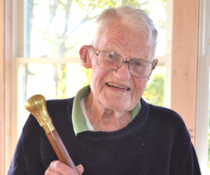 Dr. Barclay Shepard, a 22-year Navy veteran, proudly holds Boothbay Harbor's Boston Post Cane, presented to him in honor of his status as the oldest citizen in town. (Charlotte Boynton photo)