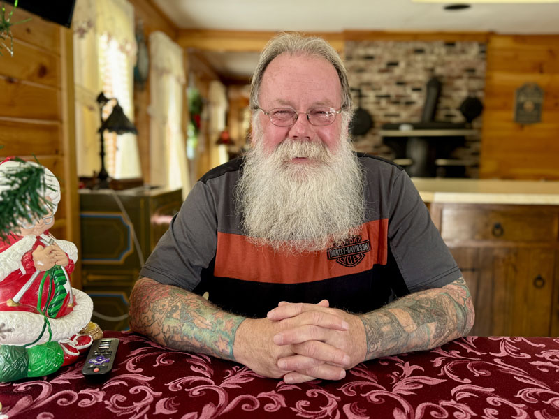 Steve Hendrix, of Bristol, sits in his home on Snowball Hill Road on Friday, Dec. 6. Hendrix, an employee of the Bristol Parks and Recreation Department, has owned his own auto repair shop, sheep farm, and antique motorcycle business. During the winter months, Hendrix travels New England, helping out Santa Claus. (Johnathan Riley photo)