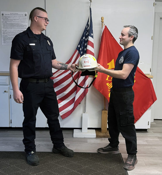 Matthew Kilpatrick (left) accepts the Nobleboro Fire Department's chief helmet from Kevin Rawley during Kilpatrick's swearing-in ceremony the afternoon of Thursday, Dec. 5. (Piper Pavelich photo)