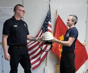 Matthew Kilpatrick (left) accepts the Nobleboro Fire Department's chief helmet from Kevin Rawley during Kilpatrick's swearing-in ceremony the afternoon of Thursday, Dec. 5. (Piper Pavelich photo)