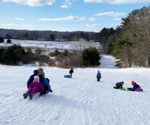 Sledding action on the big hill at Salt Bay Farm during a Coastal Rivers Conservation Trust sledding party. (Courtesy photo)