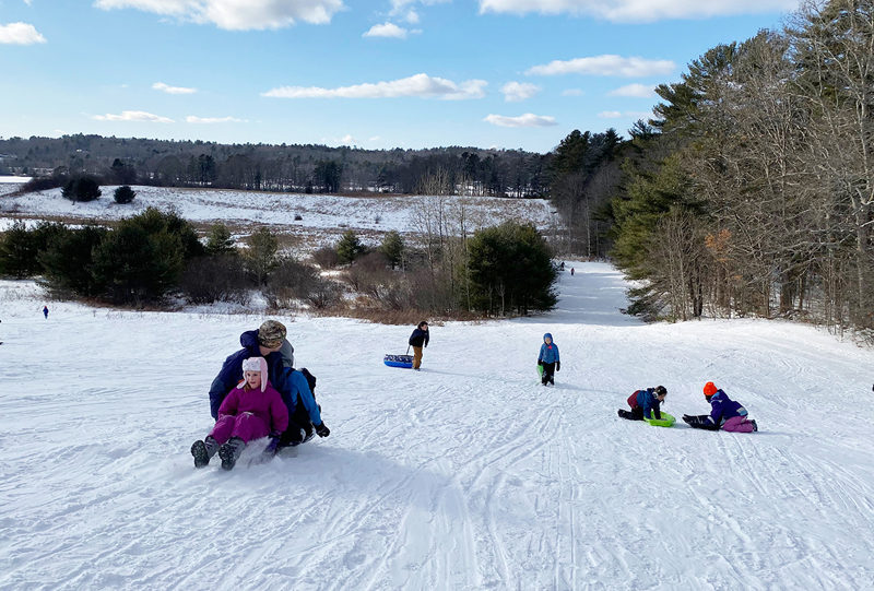 Sledding action on the big hill at Salt Bay Farm during a Coastal Rivers Conservation Trust sledding party. (Courtesy photo)