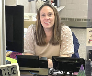 Samantha Adickes sits at her desk near the main entrance of Great Salt Bay Community School in Damariscotta. Adickes said she never planned on working in a school, but she has grown to love her job. (Sherwood Olin photo)