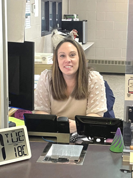 Samantha Adickes sits at her desk near the main entrance of Great Salt Bay Community School in Damariscotta. Adickes said she never planned on working in a school, but she has grown to love her job. (Sherwood Olin photo)