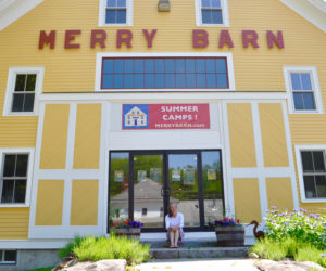 The Merry Barn Writer's Retreat founder Stephanie McSherry sits in front of the historic barn, which she converted into a literacy and arts center in 2019. The center closed at the end of 2024. In the Midcoast, McSherry said, community members value creativity, art, and freedom of thought, making the environment a welcoming one for the center. (Photo courtesy Stephanie McSherry)