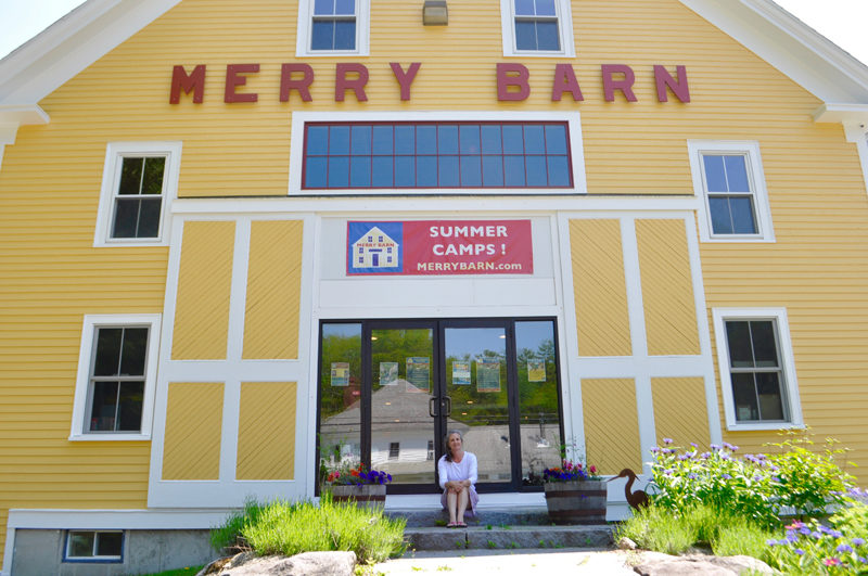 The Merry Barn Writer's Retreat founder Stephanie McSherry sits in front of the historic barn, which she converted into a literacy and arts center in 2019. The center closed at the end of 2024. In the Midcoast, McSherry said, community members value creativity, art, and freedom of thought, making the environment a welcoming one for the center. (Photo courtesy Stephanie McSherry)