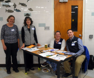 From left: Eileen Johnson, of Bowdoin College; Kristen Grant, of Maine Sea Grant; Karen-Ann Hagar-Smith, Lincoln County's community navigator; and Michael Pepin, of Midcoast Maine Community Action, greet community members arriving for a free dinner at Medomak Valley High School in Waldoboro on Nov. 14. During the dinner, attendees and discussion facilitators recalled their experiences during last winter's damaging storms and brainstormed ideas to make Lincoln County more resilient to severe weather events. (Molly Rains photo)