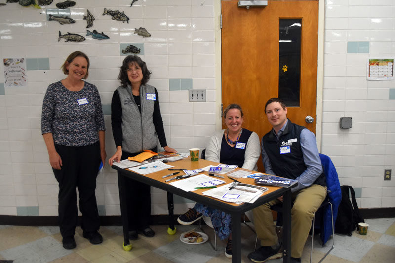 From left: Eileen Johnson, of Bowdoin College; Kristen Grant, of Maine Sea Grant; Karen-Ann Hagar-Smith, Lincoln County's community navigator; and Michael Pepin, of Midcoast Maine Community Action, greet community members arriving for a free dinner at Medomak Valley High School in Waldoboro on Nov. 14. During the dinner, attendees and discussion facilitators recalled their experiences during last winter's damaging storms and brainstormed ideas to make Lincoln County more resilient to severe weather events. (Molly Rains photo)