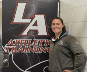 Lincoln Academy athletic trainer Megan Day stands in front of her office door in Newcastle. Day joined the school full time in fall 2015. (Paula Roberts photo)