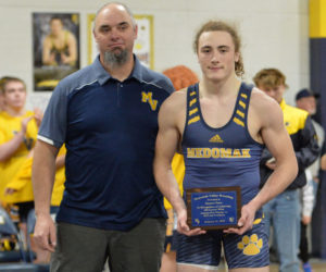 Medomak Valley wrestling coach Jeb Harris presents junior Shamus Pease with a plaque in honor his 100th career win, which Pease earned on Jan. 8. (Paula Roberts photo)