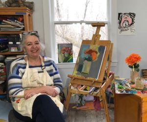 Artist and art teacher Sally Wattles poses in her Whitefield home studio with an in progress painting on March 20. Wattles prefers to paint landscapes en plein air, but part of her creative recovery is doing what she can when she can, and connecting with a community of artists both online and through her business, Coastal Maine Art Workshops. (Sarah Masters photo)