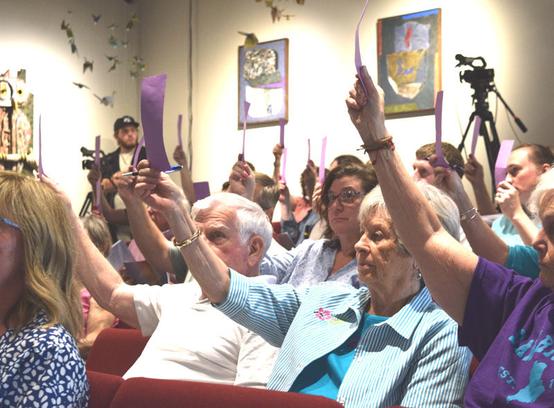 Damariscotta residents raise their vote cards to approve a budgetary article during the annual town meeting on Wednesday, June 11. Voters ultimately approved all articles related to the $4.5 million municipal budget. (Ali Juell photo)