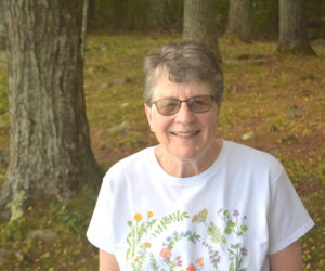 Joan Jackson smiles among pine trees on the shore of Damariscotta Lake. During her childhood in Jefferson, outdoor fun revolved around the lake, which Jackson loves deeply to this day, she said. (Molly Rains photo)