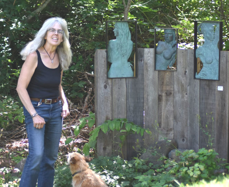 Daphne Pulsifer stands in the sculpture garden she has curated as a place to welcome visitors to her art studio on Monhegan Island. Pulsifer, who calls Monhegan and nearby Manana Island home, said her artwork is inspired by moments of connection with others. (Molly Rains photo)