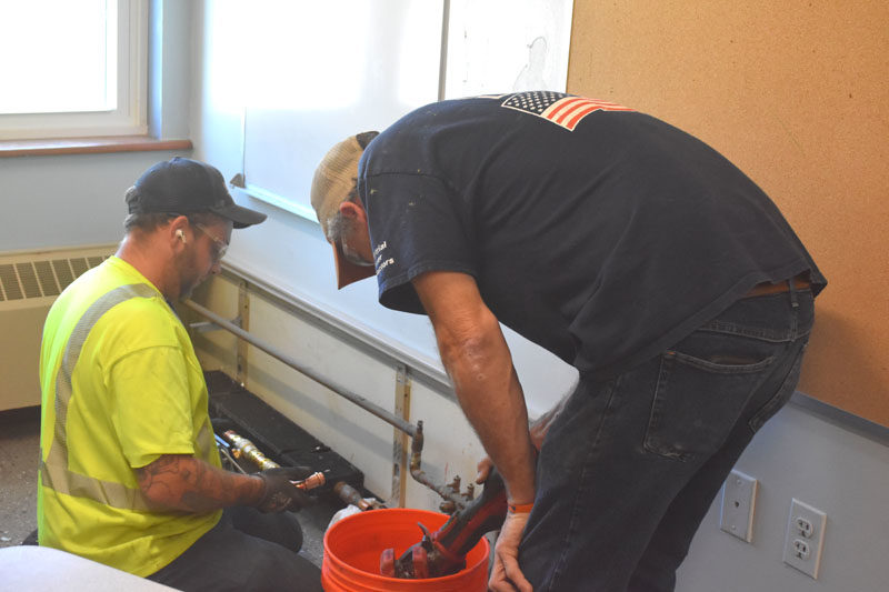 Contractors Nick Hendricks and Jesse McNair replace aged valves and controls at Miller School in Waldoboro on Wednesday, Aug. 13. The new valves will allow the school to save on energy costs and relieve educators and students from fluctuating temperatures in the building, according to RSU 40 Facilities Director Brian Race. (Molly Rains photo)