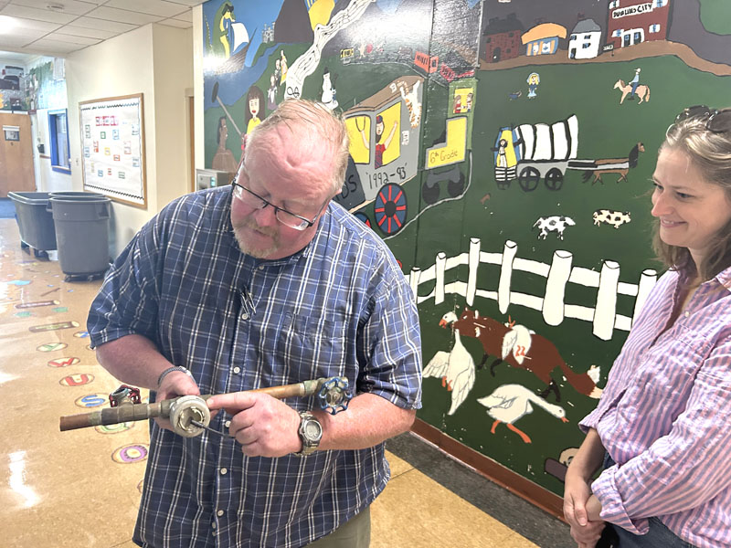 RSU 40 Facilities Director Brian Race holds an aged valve removed from Miller School in Waldoboro, which he estimated dated to the 1970s or 1980s, while RSU 40 Board of Directors member Leah Shipps, of Waldoboro, looks on. (Molly Rains photo)