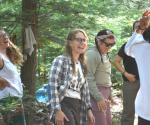 Susan Chlebowski (center) laughs with forest school participants on the morning of Friday, Aug. 15. Chlebowski welcomed accredited forest school instructors and educators to her Waldoboro property that week for an intensive workshop in outdoor education. Forest school, Chlebowski said, "is a chance for (children) to just be, to sink into their childhood and their own interests, and then have all the benefits of nature." (Molly Rains photo)