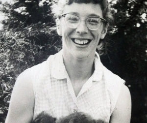 A young Nancy Holmes with an armful of orphaned raccoons. (Photo courtesy Peter Holmes)