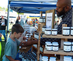 An attendee of the 2024 Maine Needham Festival samples jam from Pembroke-based Pen & Cob Farm. (Photo courtesy Drew Soucy Media)