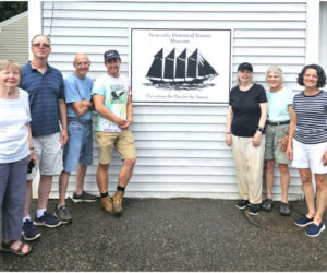 Newcastle Historical Society board members celebrate a recently installed replacement sign designed and created in collaboration with Lincoln Academy faculty member for ATEC, Andrew Jonash. From left: Sandra Barth, Tim Dinsmore, Mike Titus, Andrew Jonash, Karen Campbell, Betsy Evans, and Karen Paz. Not pictured: Bruce Campbell and Arlene Cole. (Photo courtesy Newcastle Historical Society)