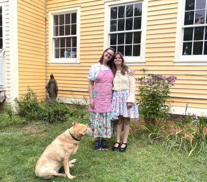 Allison (left) and Agnes Eddyblouin share a moment outside the family home on Poor Farm Road in Bristol as dog Golda keeps watch. Thrifty and resourceful, John and Allison Eddyblouin paid cash for the property in 2002. (Sherwood Olin photo)