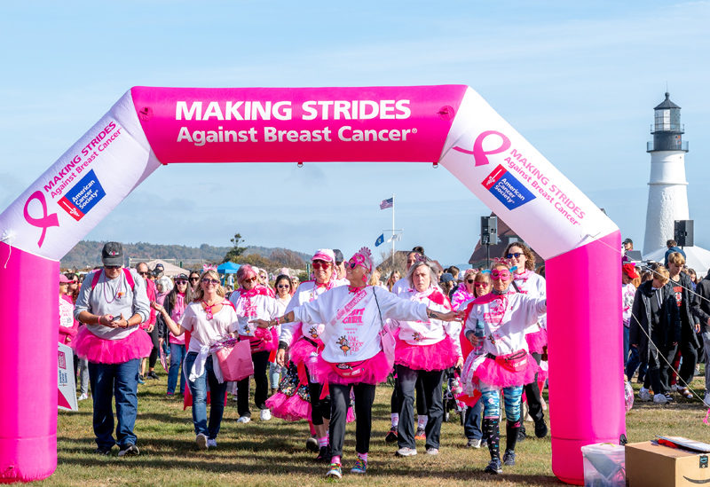 Mindy Starr-Pfahler (front) and the Fight Like A Girl team walk under the inflatable pink Making Strides Against Breast Cancer arch in Portland on Sunday, Oct. 19. The Portland Head Light provided a picturesque backdrop for the walk. (Bisi Cameron Yee photo)